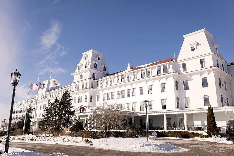 Exterior of large, white, multi-storied hotel with snow on the ground