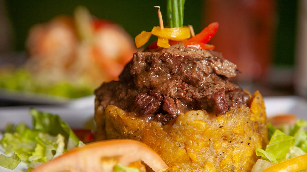 A plate of monfogo. Mofongo consists of fried mashed plantains, which is very popular amongst the people of Puerto Rico .