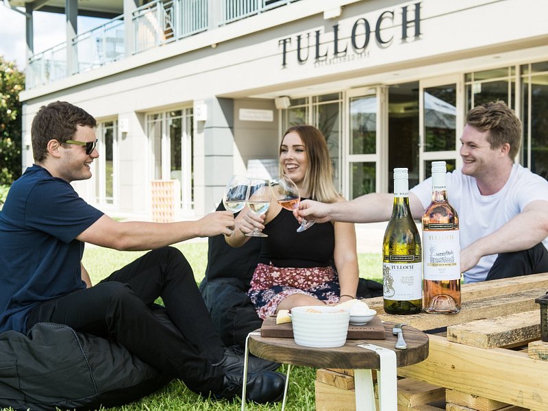 Um grupo de clientes a desfrutar de uma prova de vinhos ao ar livre na Tulloch Cellar Door