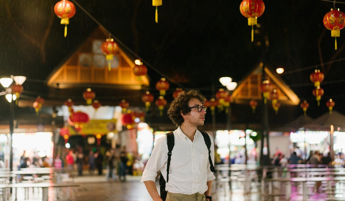 Male tourist enjoying hawker market surrounded by Chinese new year decoration 