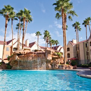 Pool and waterfall between property buildings.