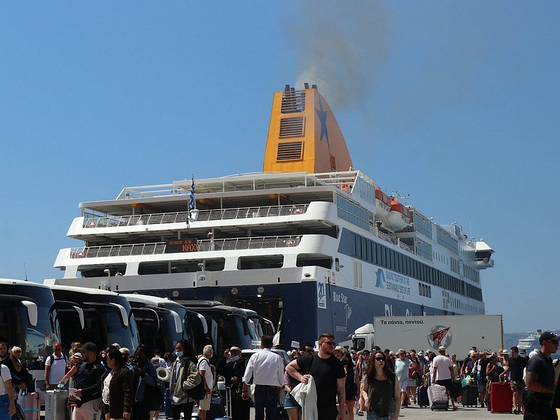 A ferry with many people in front of it 