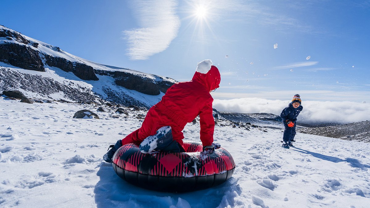 Two kids playing snow tubing in the winter