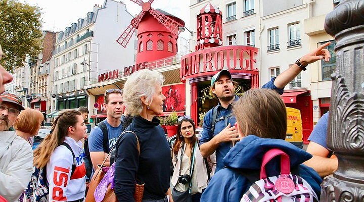 A group of people outside the Moulin Rouge building