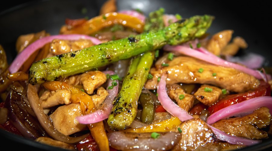 Wok de pollo con salteado de verduras y espárragos trigueros.