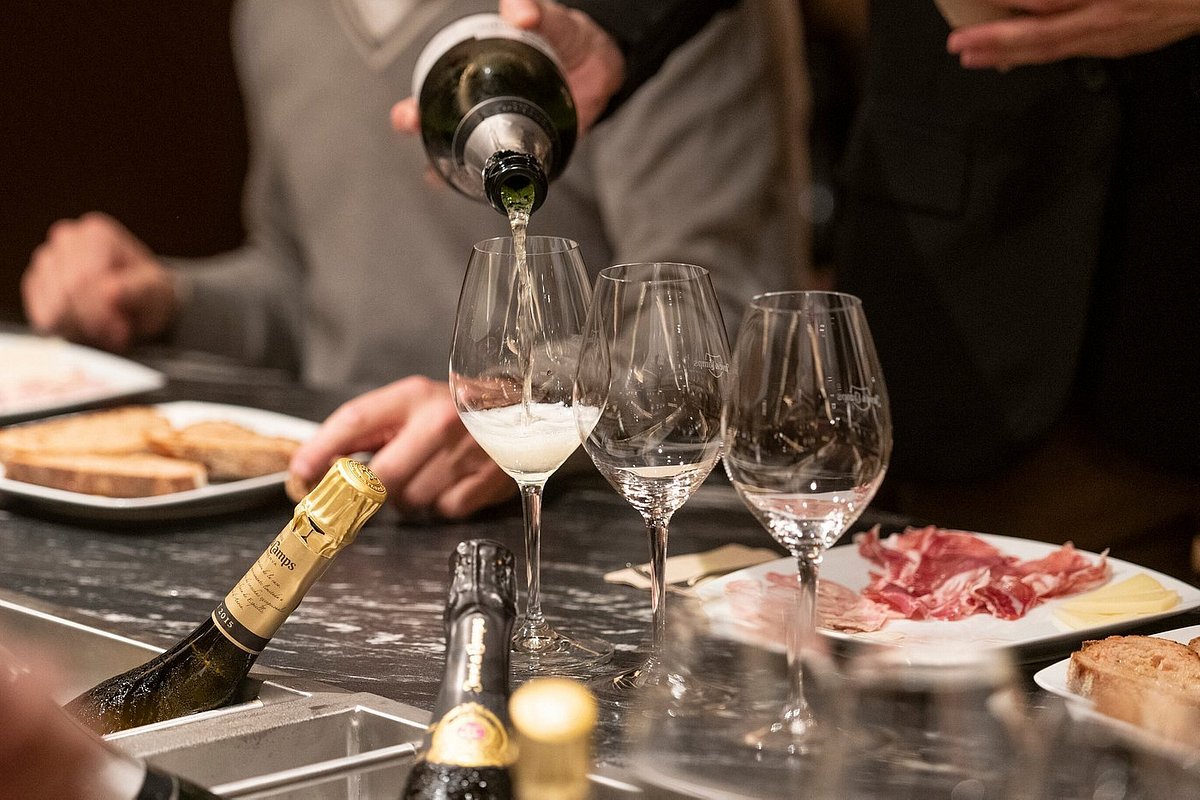 テイスティングでグラスにワインが注がれ、テーブルの上にハム類が置かれている