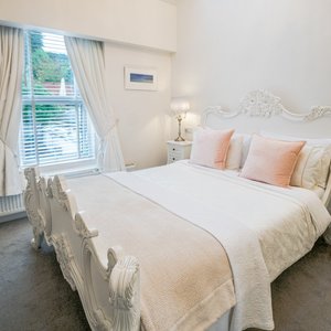 A beautiful room on the 1st floor at the back of the house overlooking the garden. Vaulted ceiling with a large chandelier, blackout remote control Velux blinds. French style furniture, a table and 2 chairs, a king sized bed with a pocket sprung mattress. Has a mini fridge, complimentary water, biscuits and milk on arrival. A large flat screen TV, Alexa and USB charging sockets.
En suite bathroom with a large walk in shower, complimentary Duck Island toiletries and towels.