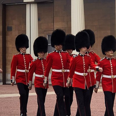 London guards in their red uniforms and tall black hats stand in organized rows