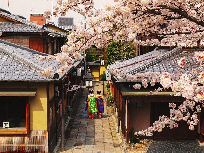 To kvinder i traditionelt japansk tøj går ned ad en gade i Kyotos Higashiyama-distrikt