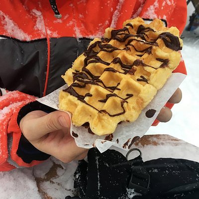 Skier holding a belgian waffle outside Waffle Cabin in Killington, Vermont