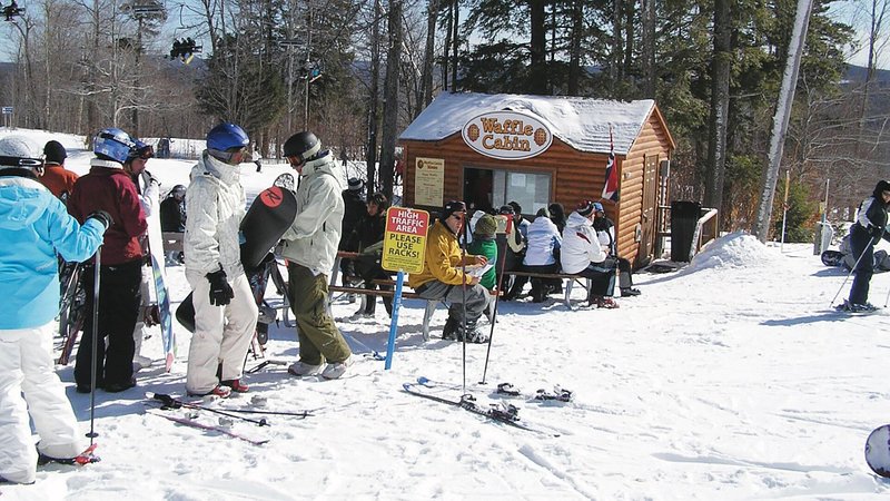 A line of skiers outside of Waffle Cabin at Okemo Mountain Resort in Vermont