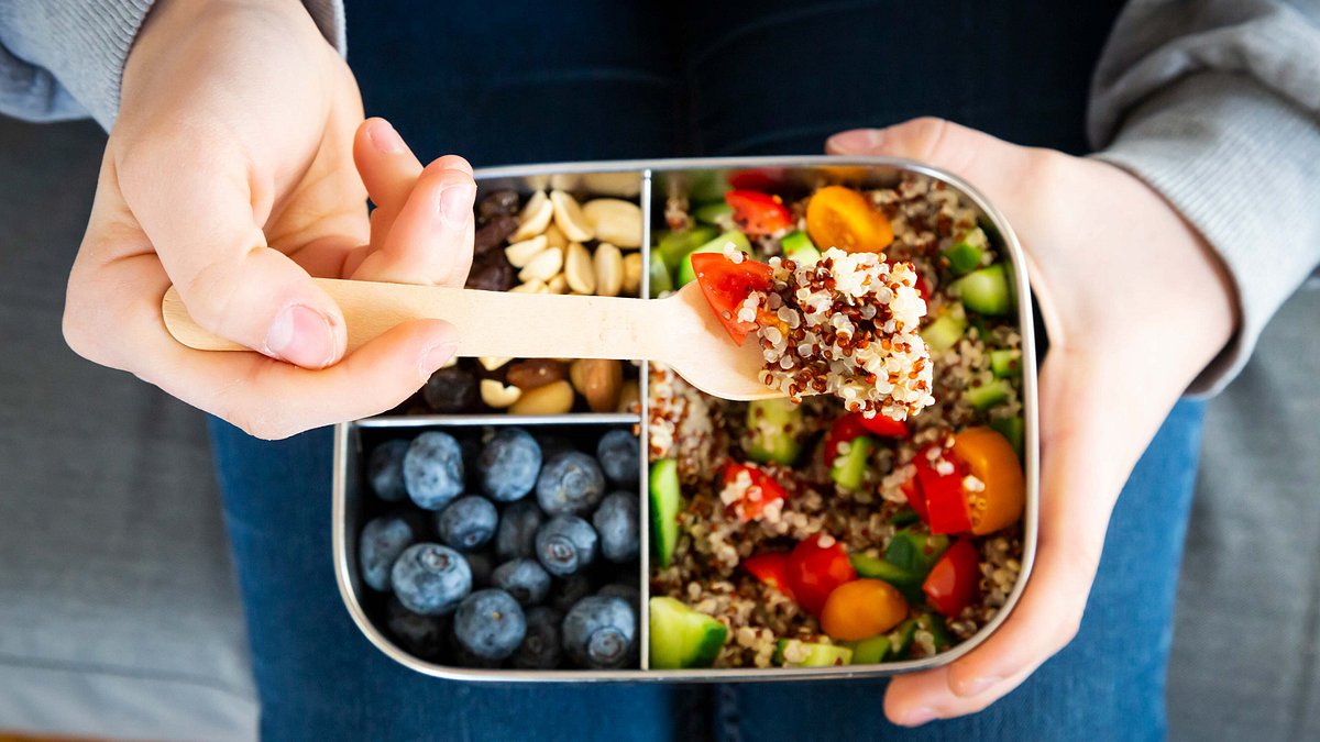 Lunchbox with quinoa salad with tomato and cucumber, blueberries and trail mix