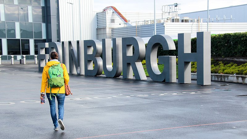 Woman walking towards  Edinburgh airport in Scotland 