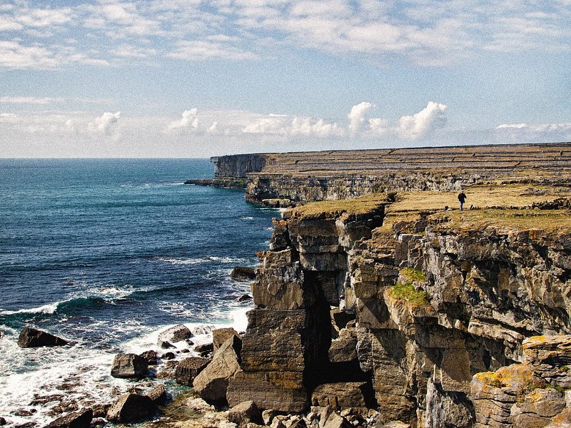 Person walking at the cliffs on Inishmore, Aran Islands, Ireland