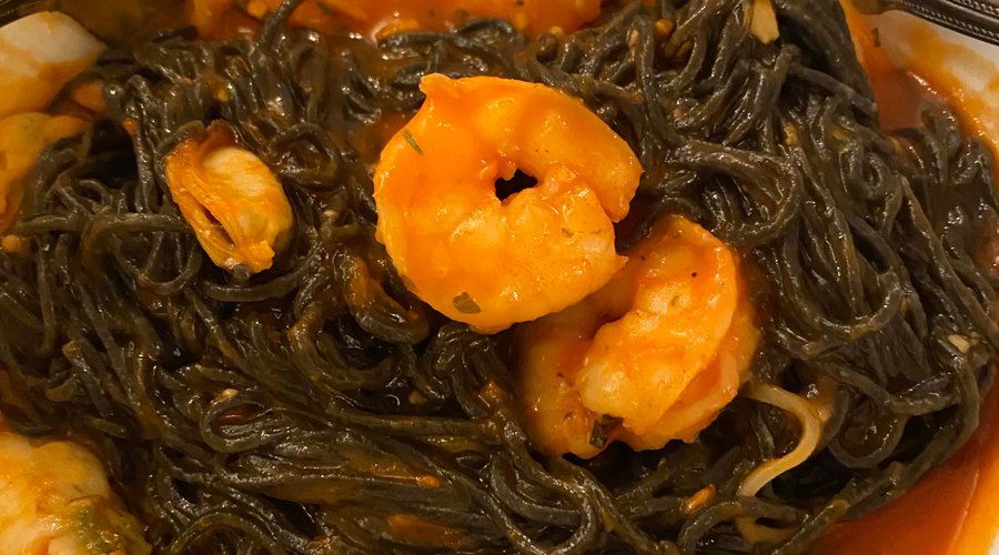 Black Capellini pasta with shrimps and mussels. 