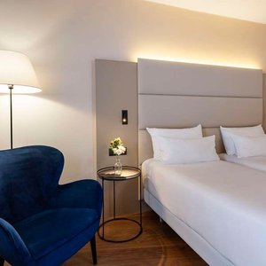 NH Geneva Airport Room standard interior twin beds blue armchair x