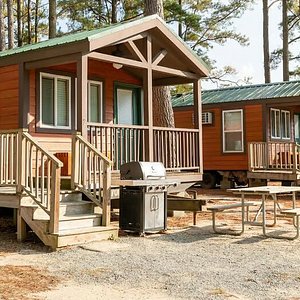 Camping cabin has one bedroom, heat/A/C, full bath, kitchen with appliances.