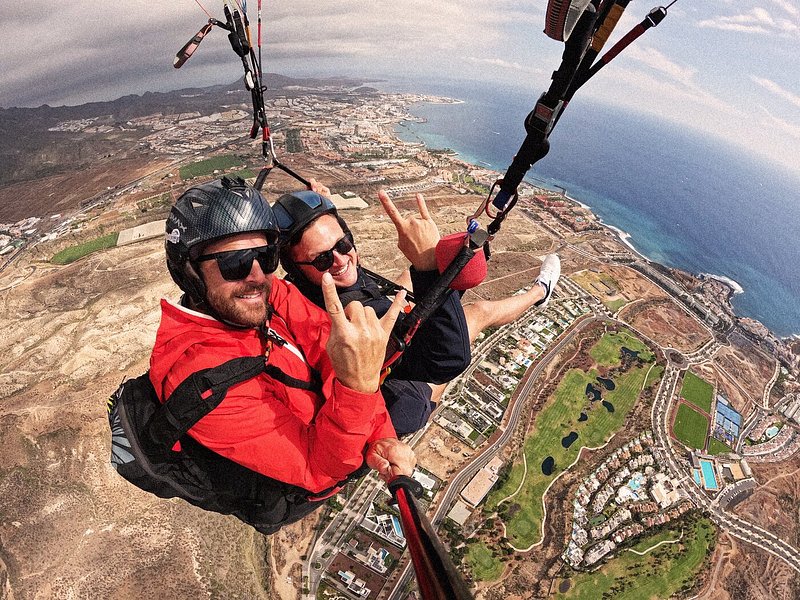 Wide angle shot of tandem paragliders flying over Tenerife