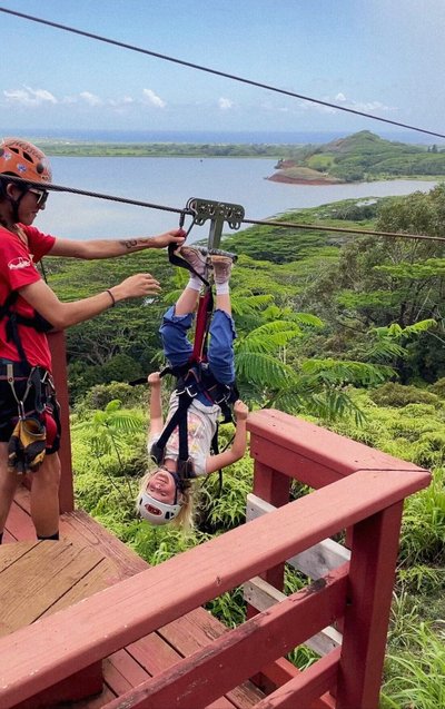 A young girl preparing to zipline upside-down in Kauai, Hawaii