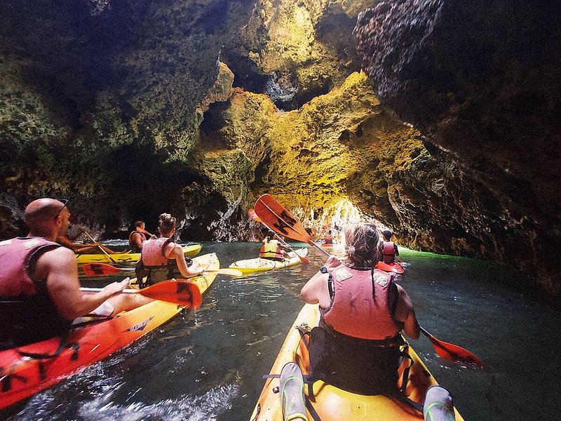 First-person view of travelers kayaking inside a sea cave near Lagos, Portugal
