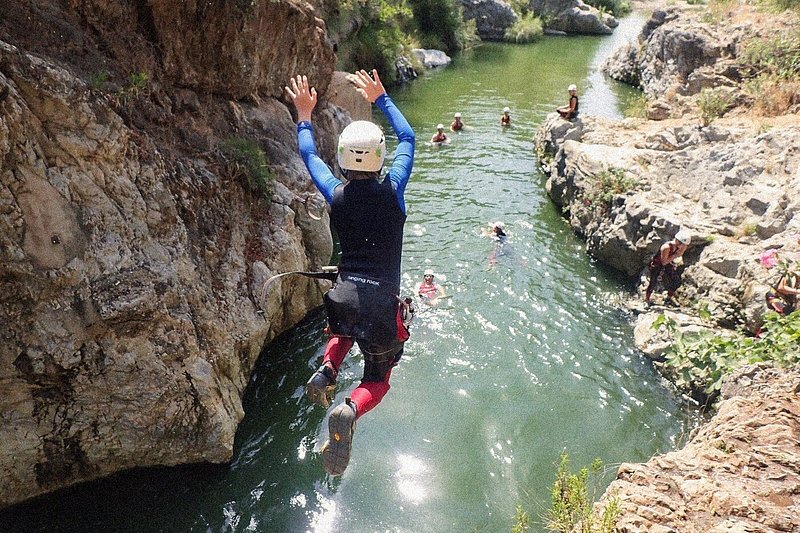 Rear view of a person leaping into a lagoon in Guadalmina Canyon, Marbella, Spain