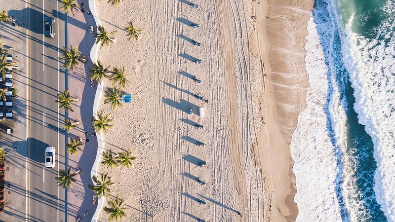 Overhead shot of car driving on road next to beach in Fort Lauderdale, Florida
