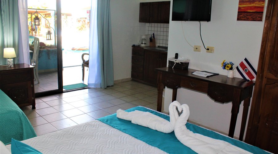 This room has 1 full bed and 1 twin bed that also serves as a sofa, a kitchenette, air conditioner, cable TV, free internet, large walk-in shower, hot water, dining table, seating area, desk, and a private patio or balcony with a pool view and a hammock. 