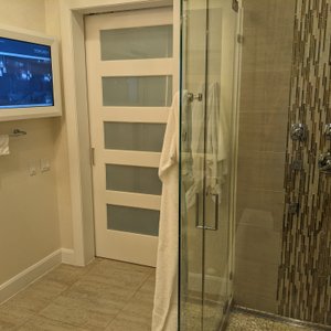 Shower, TV, and barn door to rest of villa.