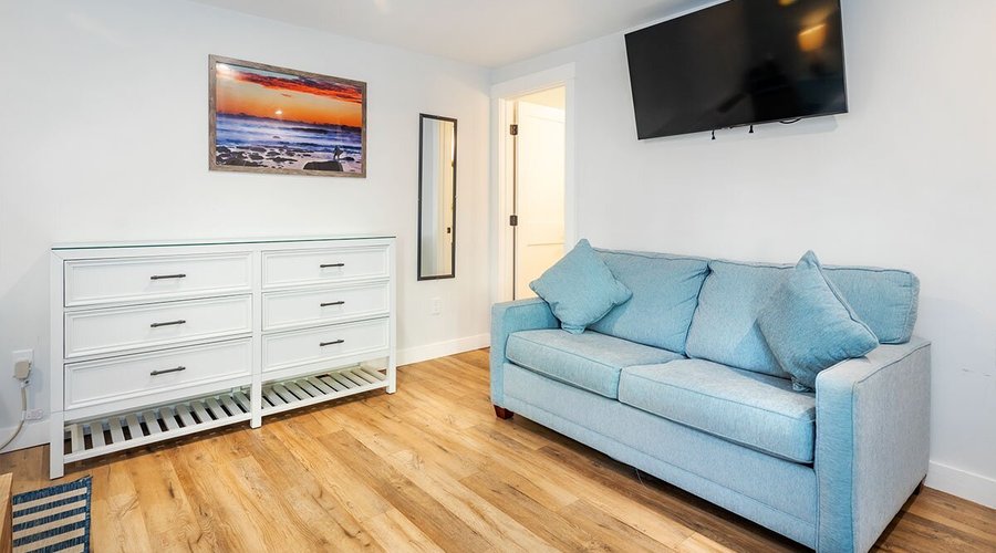 Sleeper sofa, dresser, and TV at the Surf House Resort on Hampton Beach