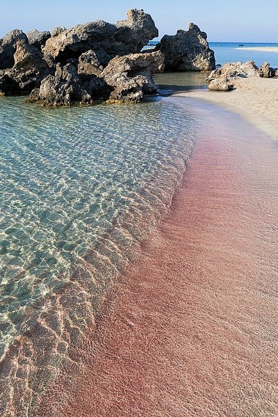 Areias cor-de-rosa ao longo da linha de água na praia de Elafonisi