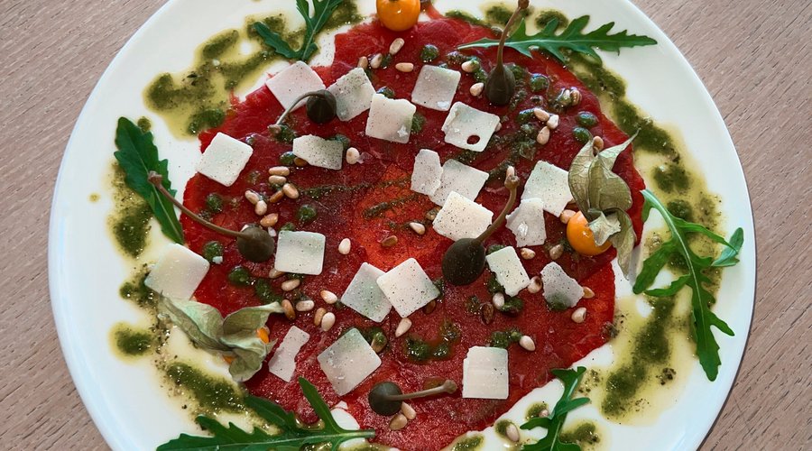 Carpaccio de ternera, pesto de rúcula y piñones tostados y parmesano. 