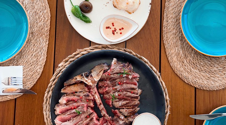 T-Bone de ternera a la brasa con guarnición de gratinado de patata, cebollas baby confitadas, pimientos del padrón. Todo acompañado de salsa de setas con trufa o salsa de pimienta.