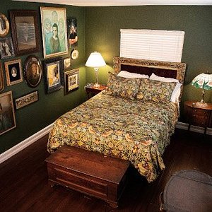 Our Portrait Room features a wall of vintage and modern photos and art near the queen size bed.