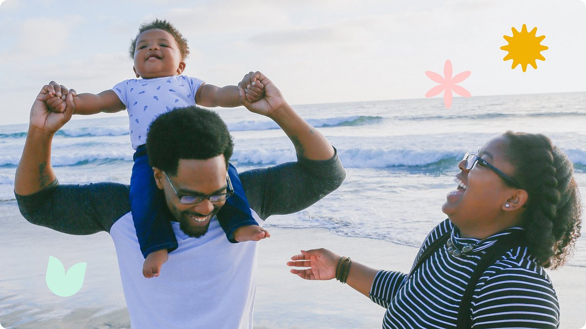 Baby on his father's shoulders with mother laughing.