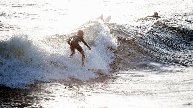 Surfers on waves, Pietrasanta, Tuscany, Italy