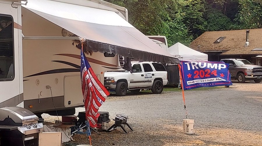 I'm on vacation and I have to look at this? Reads 'Make Votes Count Again.' The flag in foreground is 2nd amendment graffiti adorned. 