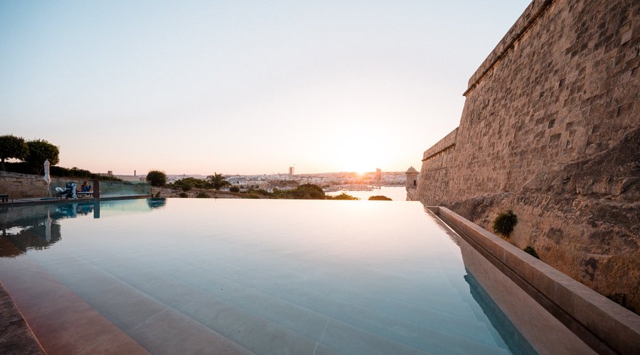 The Phoenicia Malta's iconic infinity pool, sitting underneath 16th century bastion walls