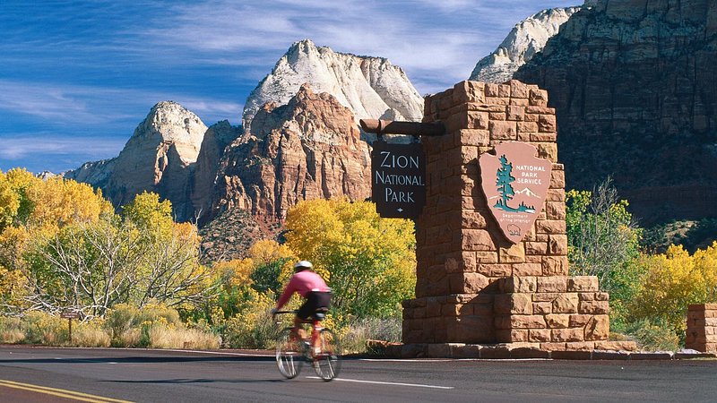 Cyclist at south entrance of Zion National Park, during autumn in Utah 