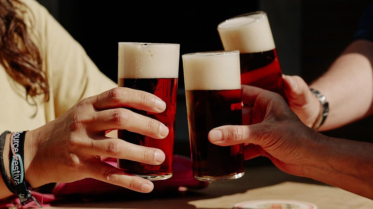 Två glas öl som höjs mot varandra i ett skålande