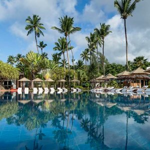 Exterior view of swimming pool with sun-loungers and umbrellas