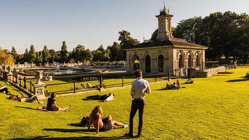 People relaxing on the lawn at Kensington Gardens, London