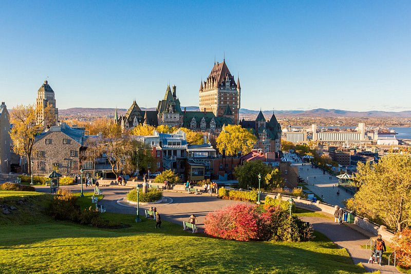 Cây xanh tươi tốt và lá mùa thu rực rỡ tại Fairmont Le Chateau Frontenac, khách sạn cổ kính ở Thành phố Quebec, Canada