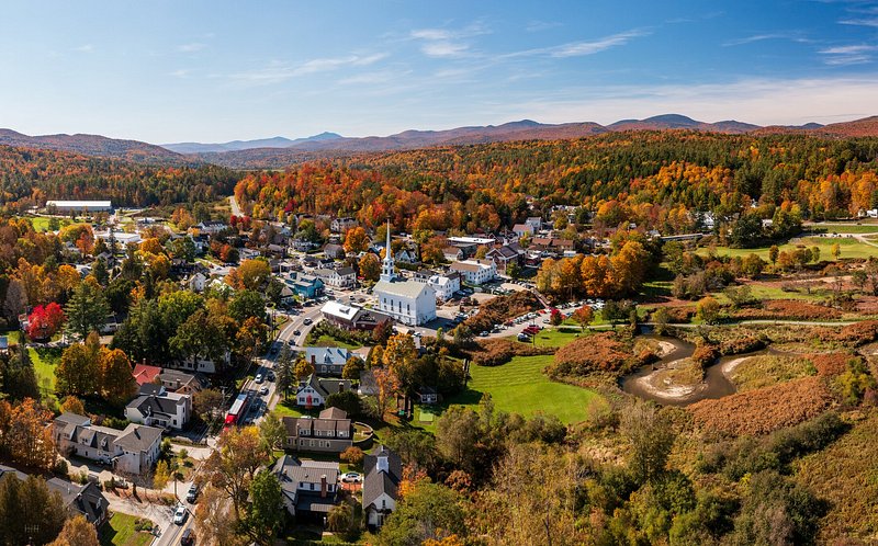Aerial view of the town of Stowe, Vermont, surrounded by lots of colourful autumn foliage