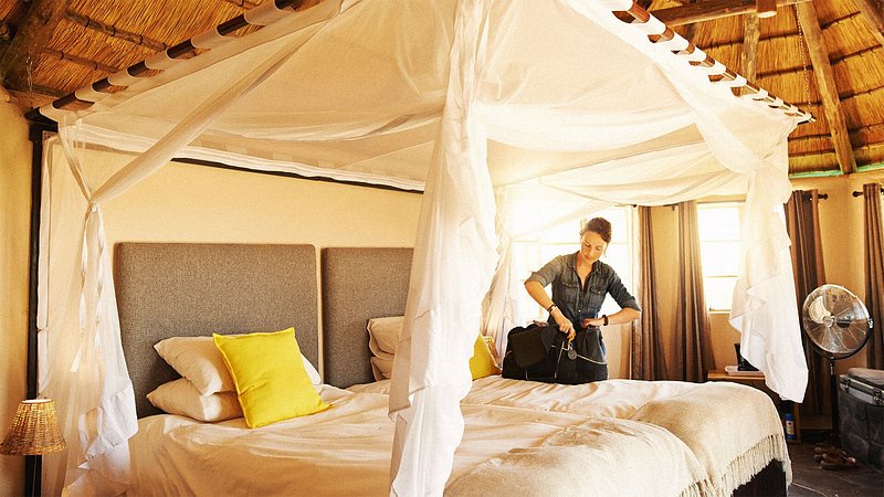 Woman unpacking luggage in hotel room 