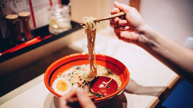 Woman eating bowl of ramen in Japan