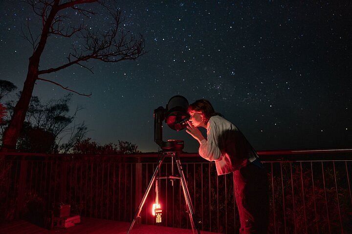 Reisende, die durch ein Computerteleskop die Sterne über den Blue Mountains, Sydney, Australien, betrachtet
