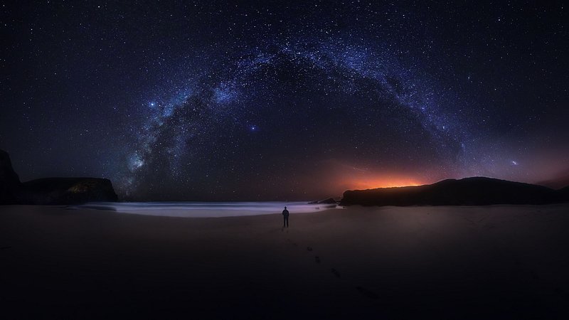 Een reiziger die de Melkweg bekijkt vanuit zuidwest-Alentejo en Vicentine Coast Natural Park.