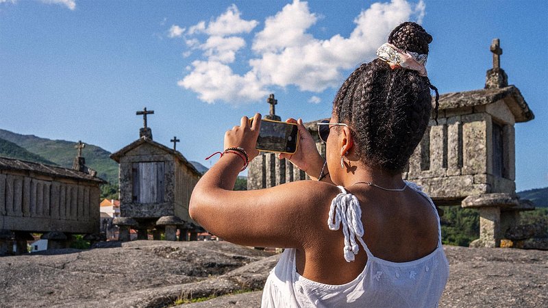Woman taking photos of granaries of Soajo, Portugal