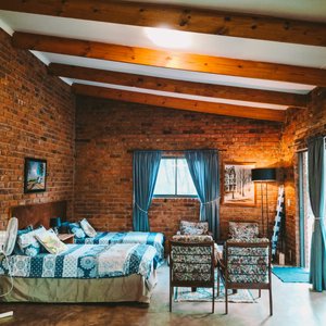 The open plan area at Star Gazer has 2 single beds, large glass sliding doors to enjoy the garden and mountain view, dining room area, indoor fireplace, fully equipped kitchen