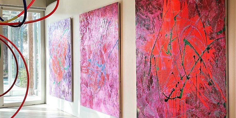 Art exhibit with colorful paintings and hula hoops